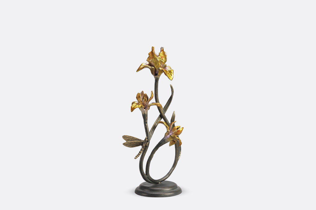 A pair of taper candleholders shaped like iris flowers with a dragonfly.