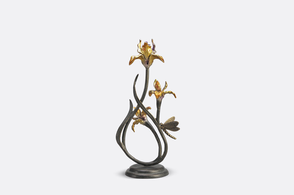 A pair of taper candleholders shaped like iris flowers with a dragonfly.