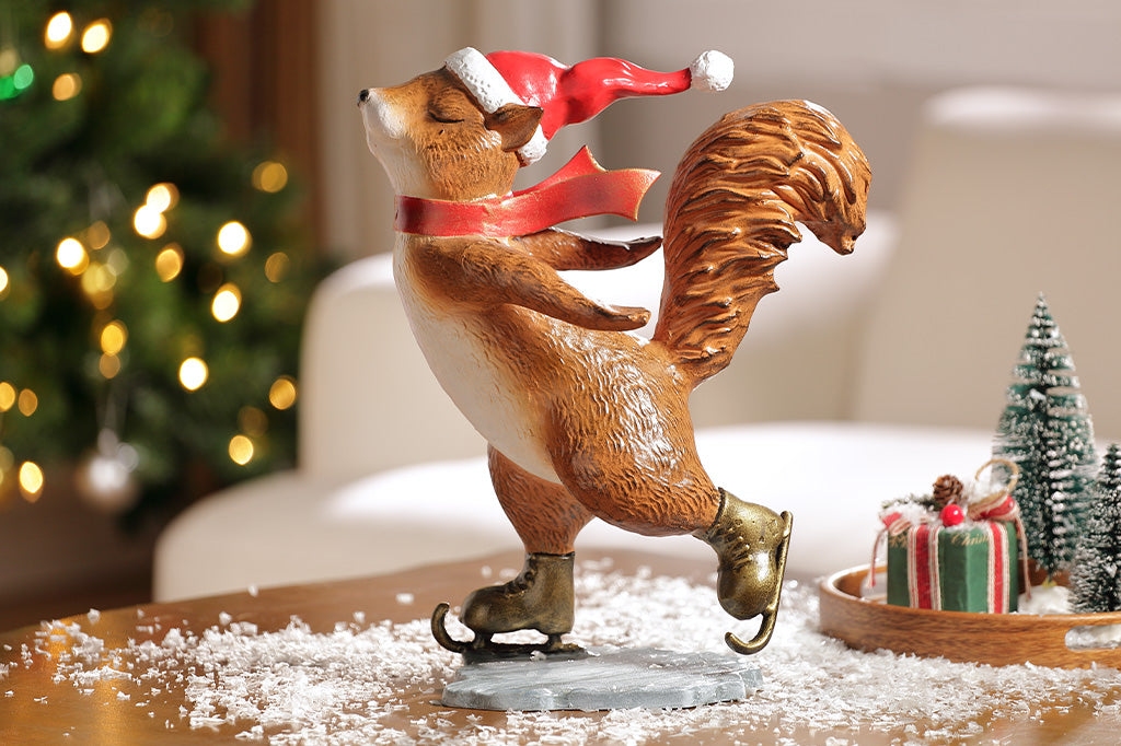 A statue of a squirrel wearing a santa hat and scarf ice skating.
