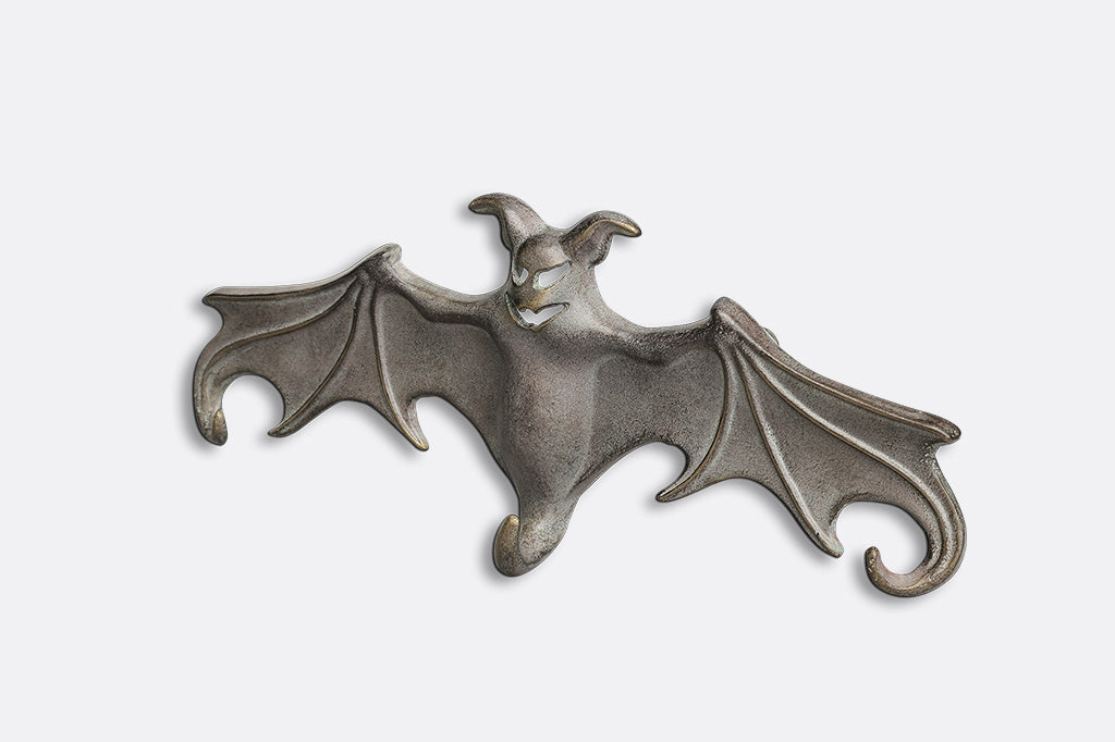 Metallic bat-shaped bottle opener on a white background