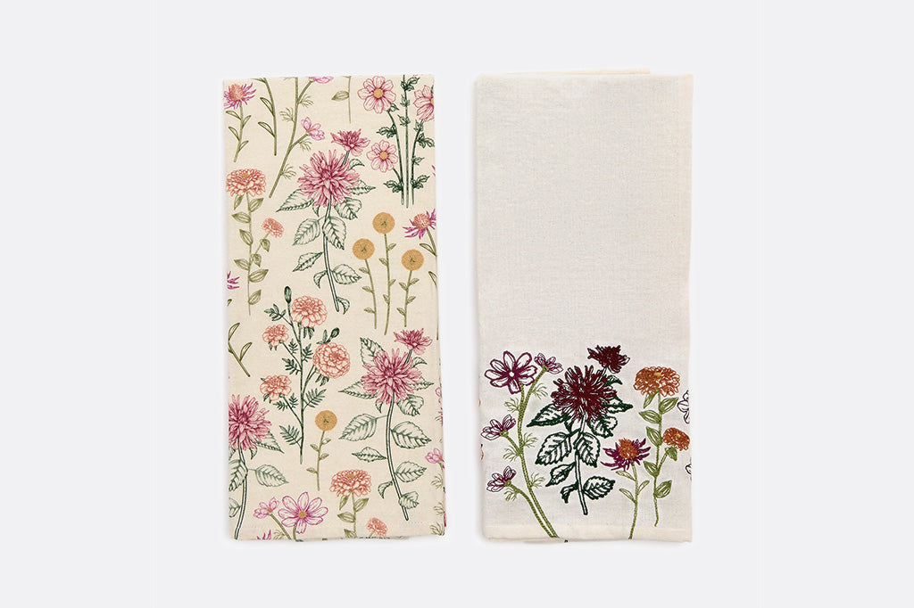 Two folded towels with detailed images of flowers.