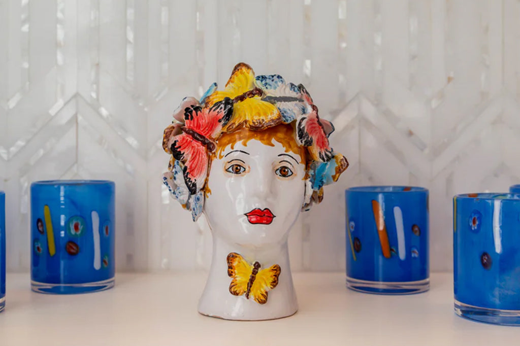 italian ceramic vase of women's head adorned with butterflies set on counter