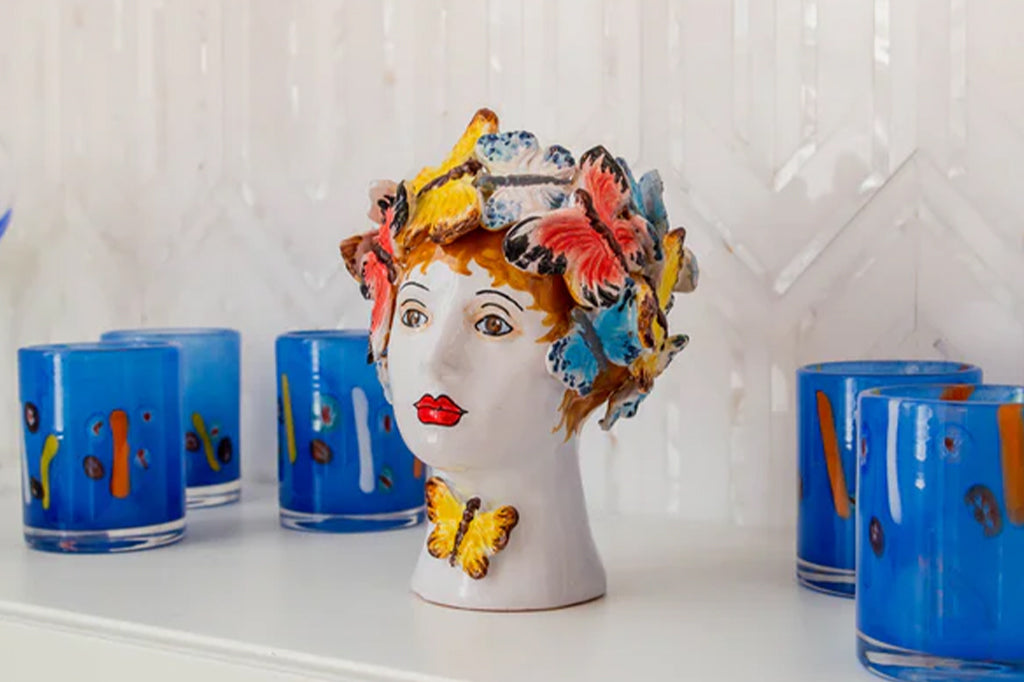 italian ceramic vase of women's head adorned with butterflies set on counter