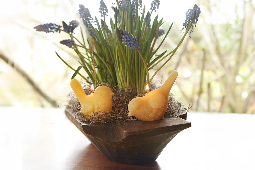 Pair of beeswax candle nestled into flower arrangement
