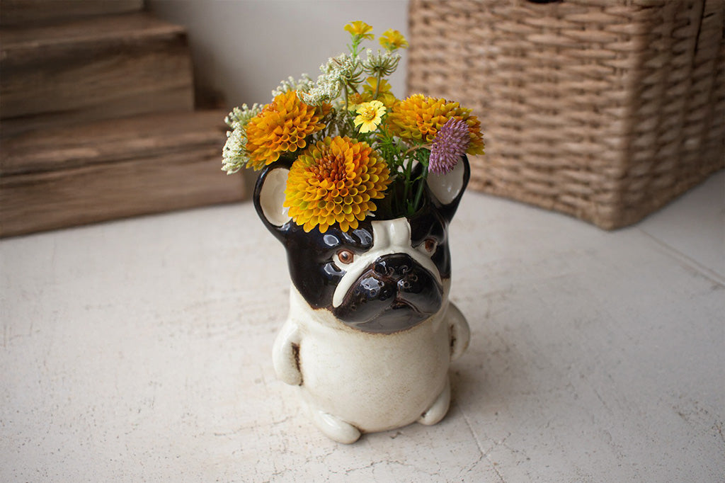 A vase shaped like a dark brown and tan pug.