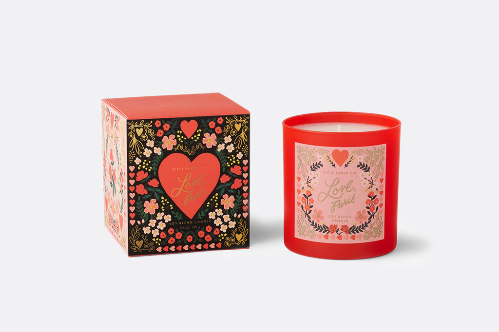 Red candle with decorative packaging on a white background