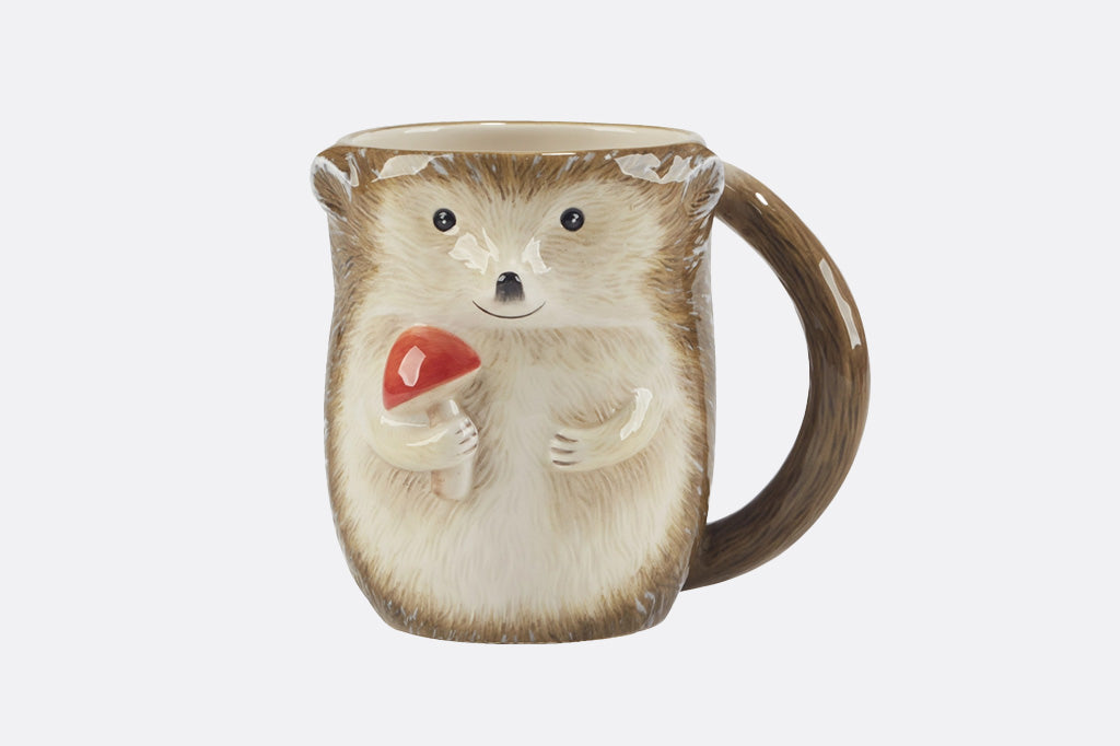 Hedgehog-shaped mug holding a red-capped mushroom