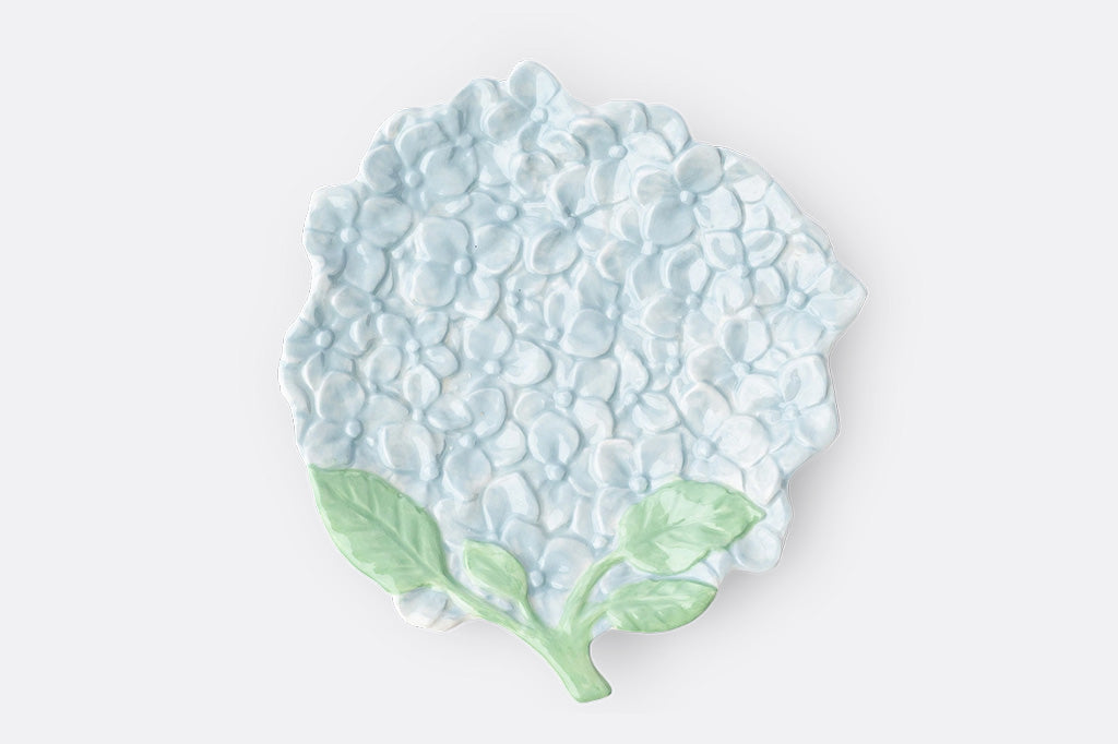 Ceramic serving plate shaped like hydrangea blossom in soft blue with green stem, relief detailing.