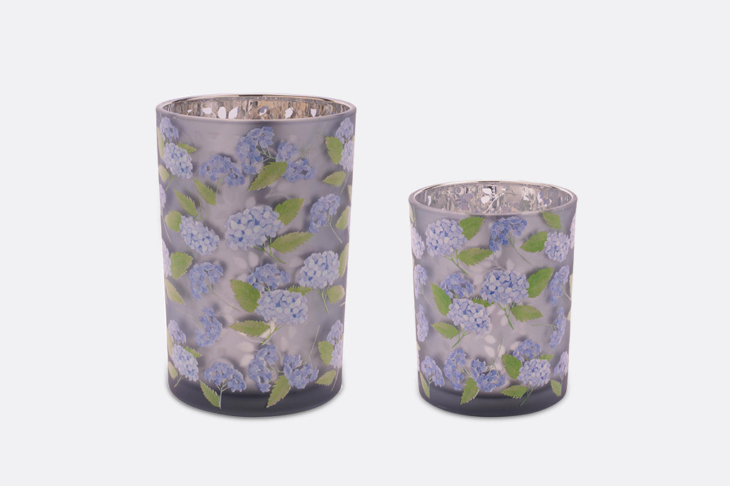 Two purple candleholders with a hydrangea flower design.