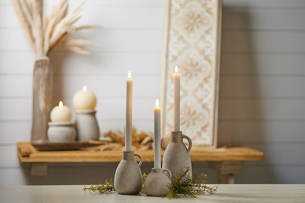 white LED taper flameless candles staged inside candle holders on counter top