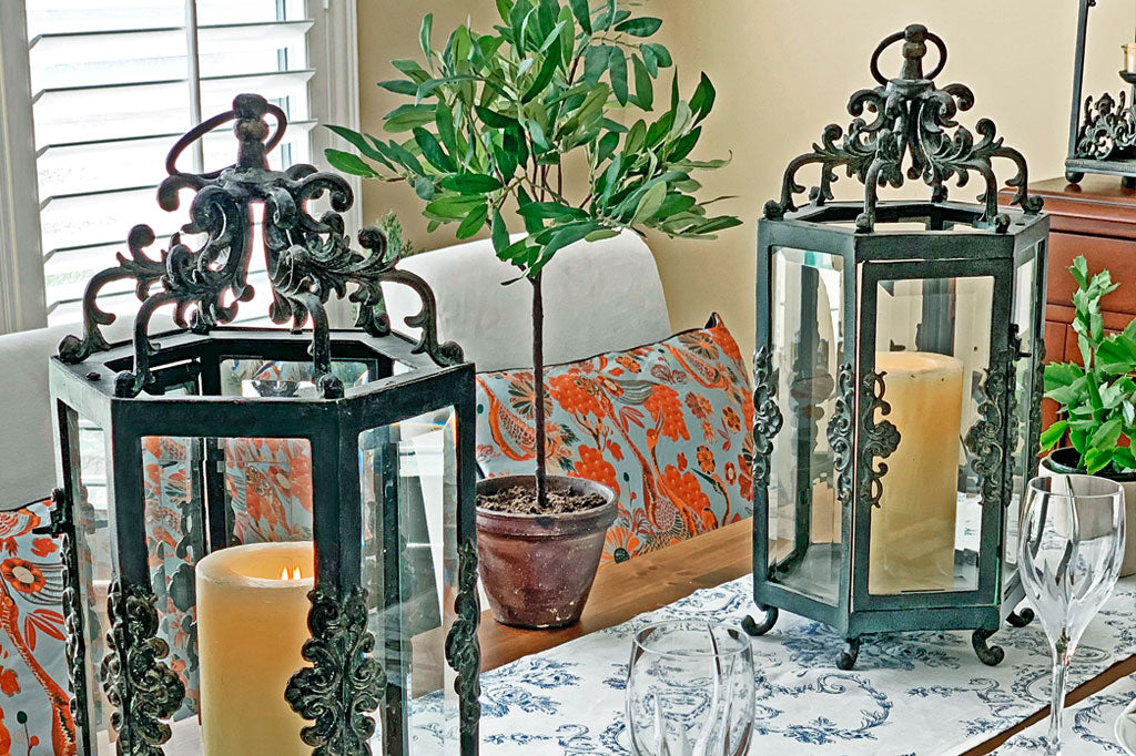 two Rouleau Six Pane Lanterns on a tabletop in formal dining room amidst topiary
