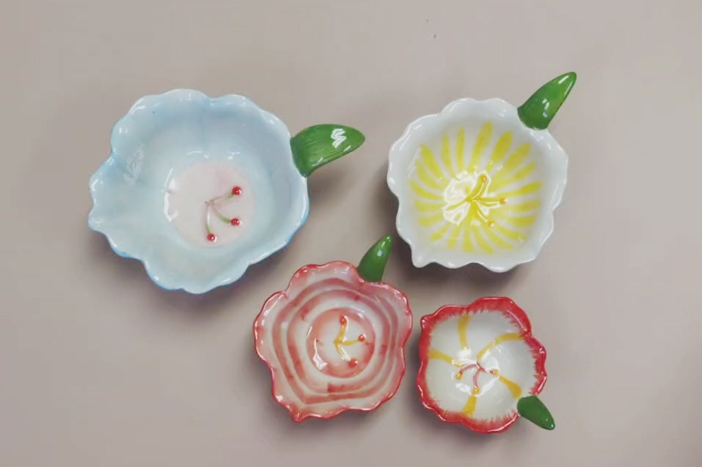 Product video showing a hand stacking floral, ceramic nesting bowls