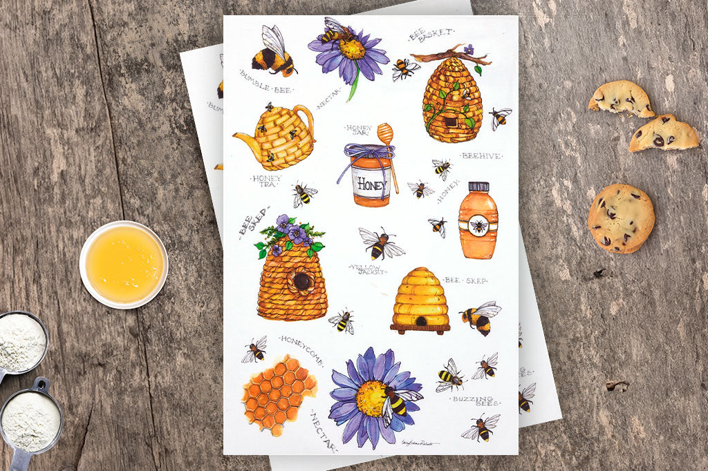 Coordinating bees and flower tea towels with honey and buzzing bees  on counter with flour, cookies, and honey bowl