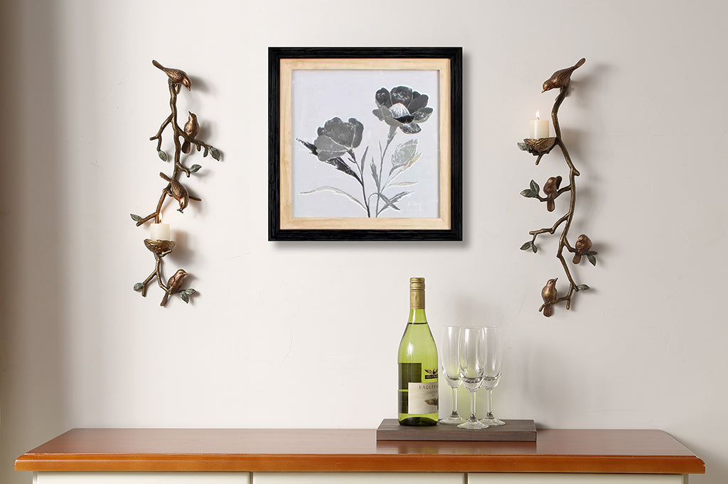 Pair of cast metal bird and nest wall sconces, holds two votive candles. Staged on wall framing a painting over a accent table. 