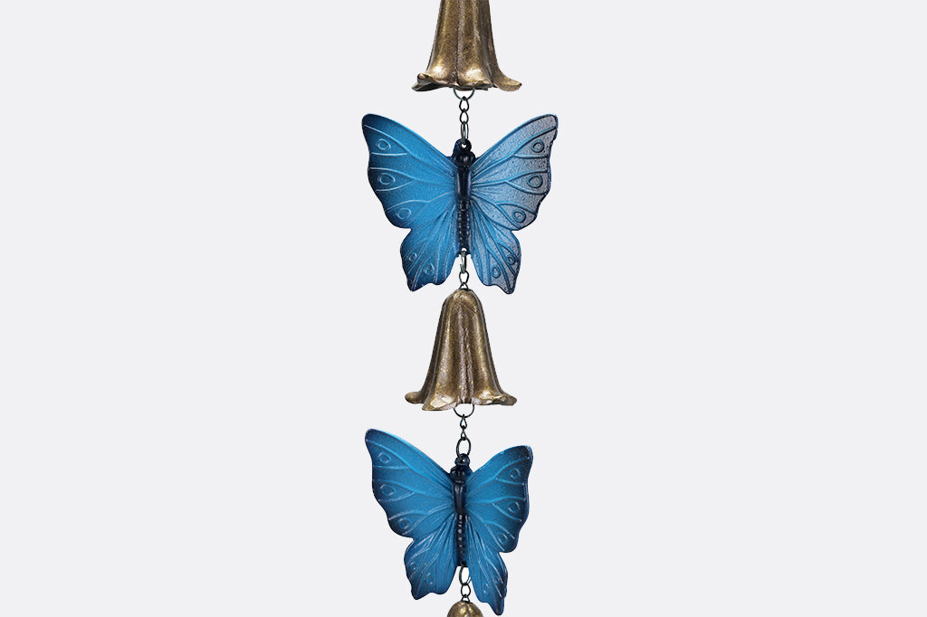 detail view of cast metal blue butterfly and bell windchime