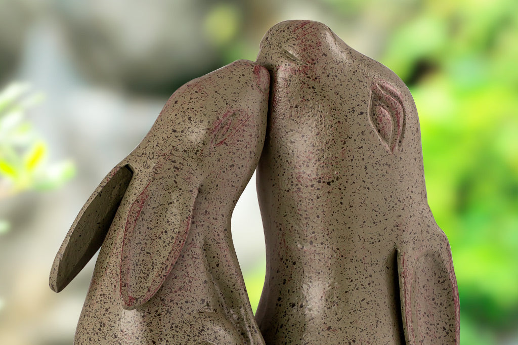 close up view of two garden sculpture bunnies nuzzling