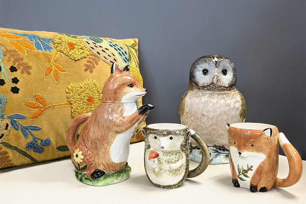 Set of ceramic animal mugs with matching fox teapot, owl cookie jar, shown on table with autumnal theme decorative pillow
