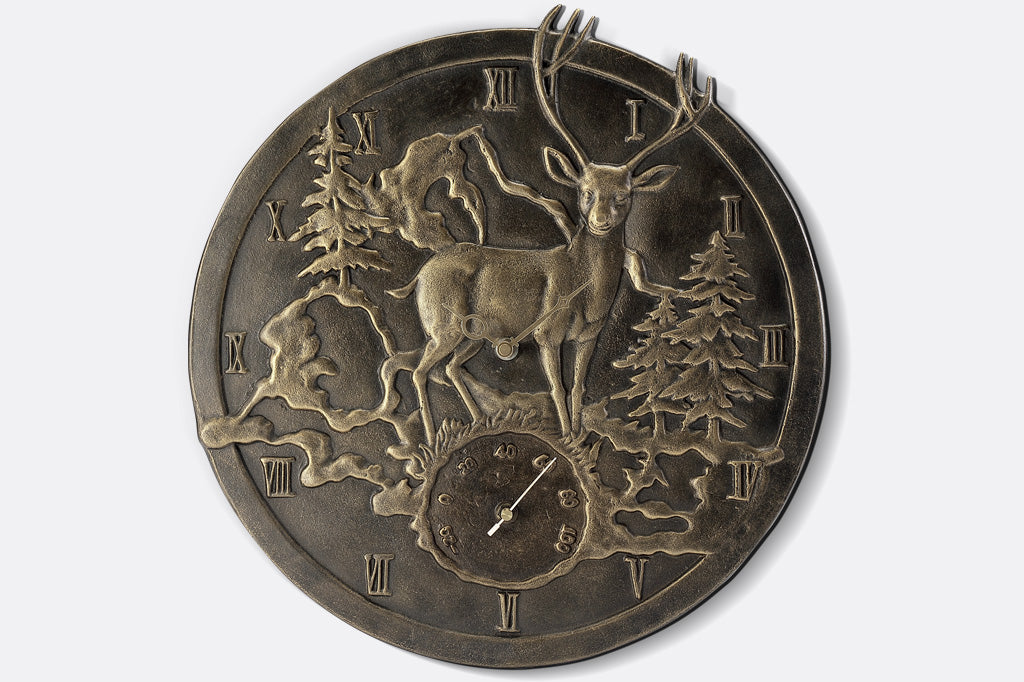 detailed view of cast metal deer in mountain scene wall clock and thermometer