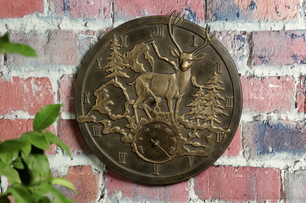 cast metal deer in woodland scene clock on outdoor brick wall