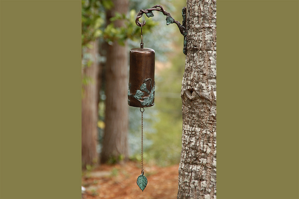 cast metal garden bell with hanger set on tree