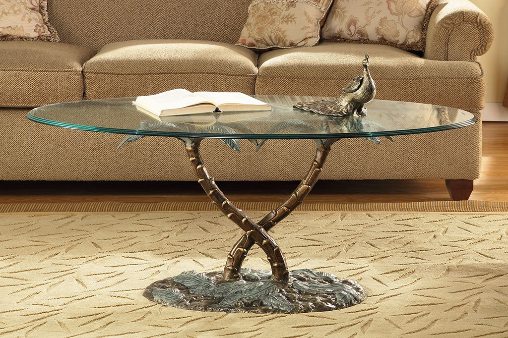 cast metal and glass table held up by palm tree