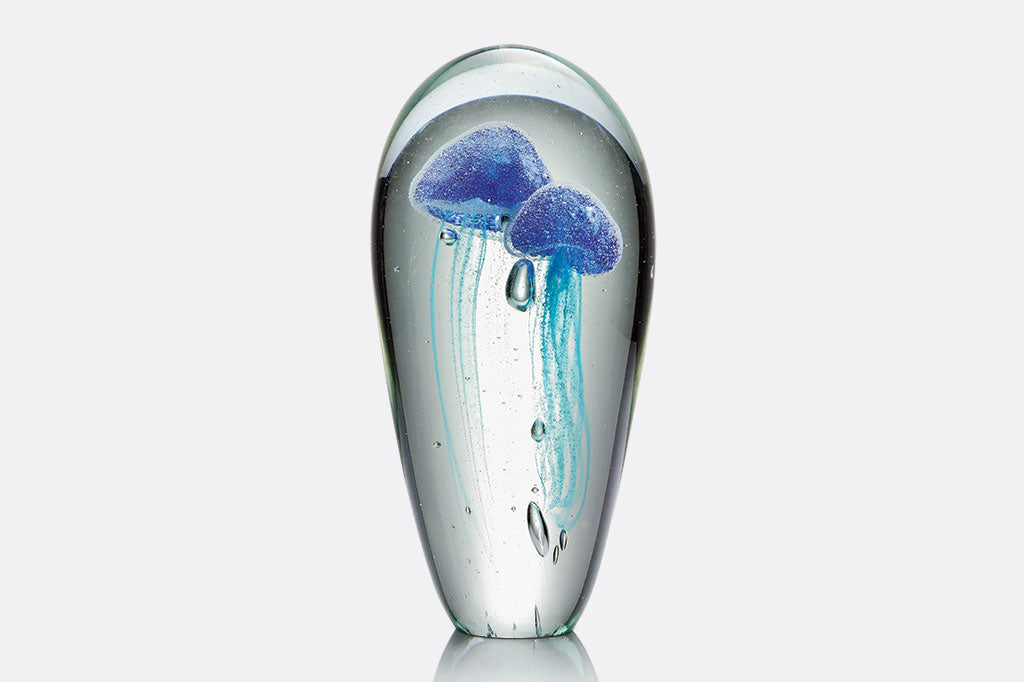 Glass desk art accessory with 2 blue blown glass jellyfish and bubbles inside. Tall oval shape