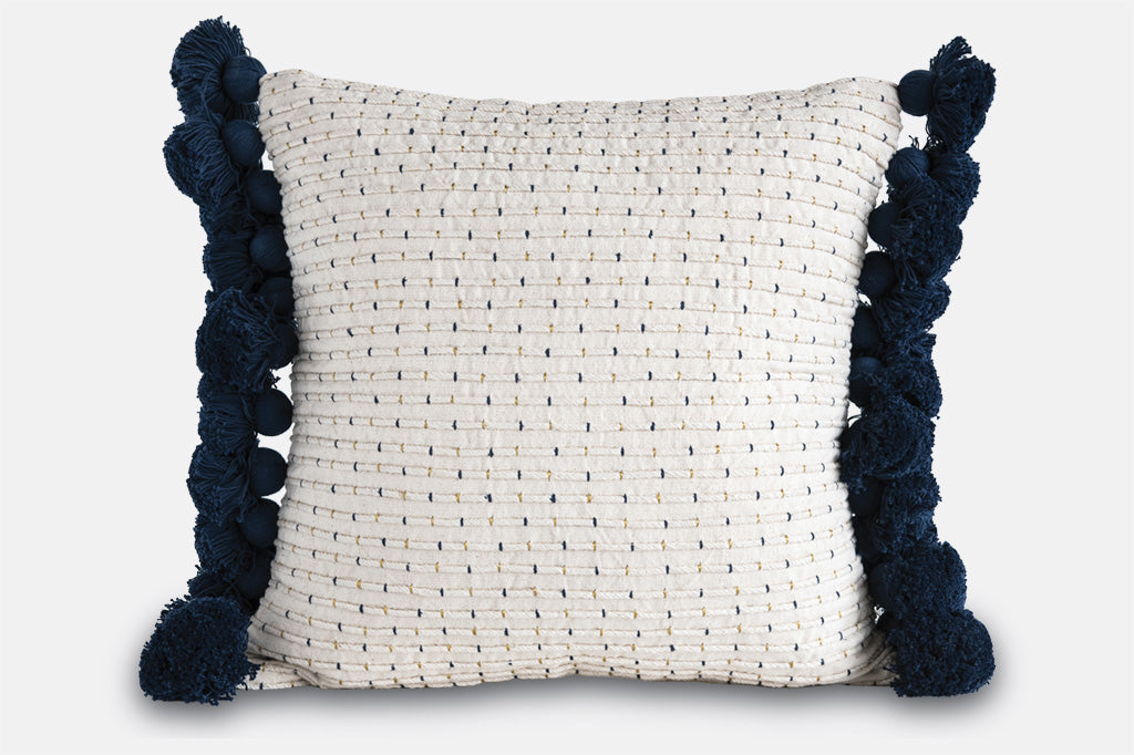 white and blue pillow with navy tassels on side