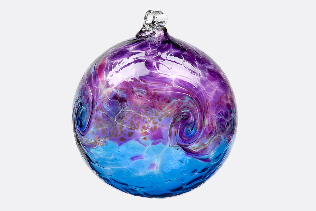 Handblown glass ornament designed to hang from metal stand