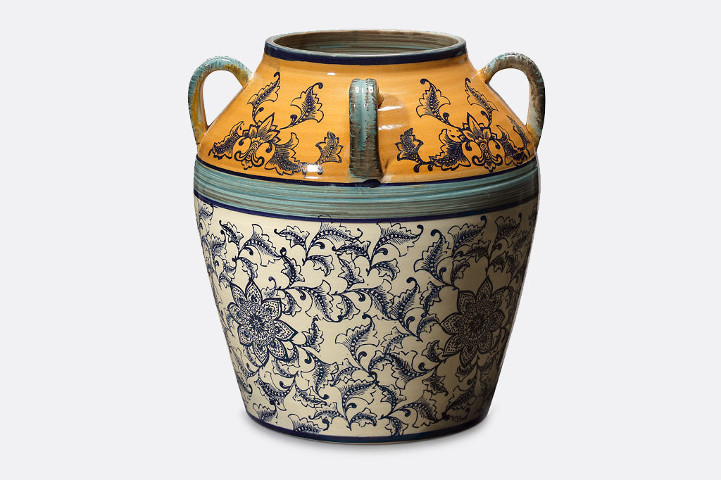hand painted and thrown ceramic pot with mediterranean prints done in vivid yellow-orange, light and dark blue with floral print on white