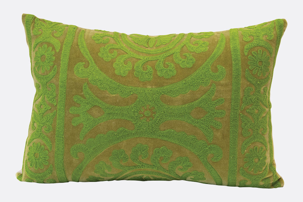 A green velvet pillow with intricate embroidery and a cushion-like shape, displayed against a white background.