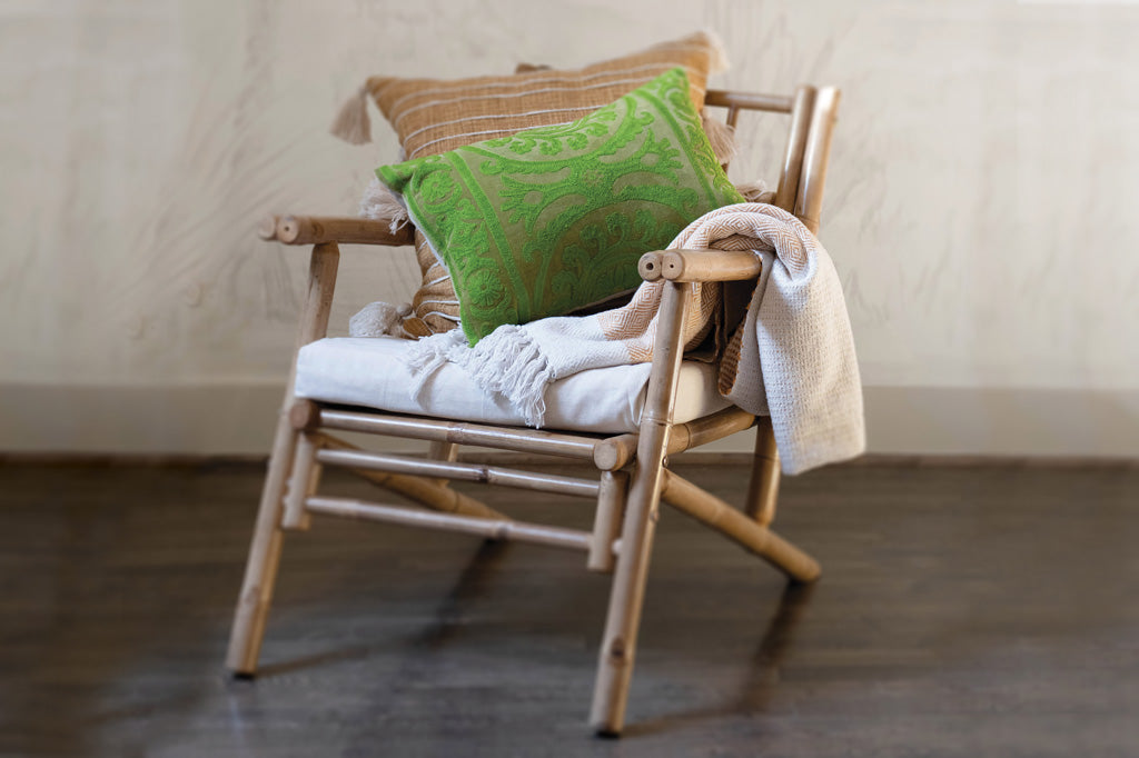 green pillow shown on bamboo boho style chair