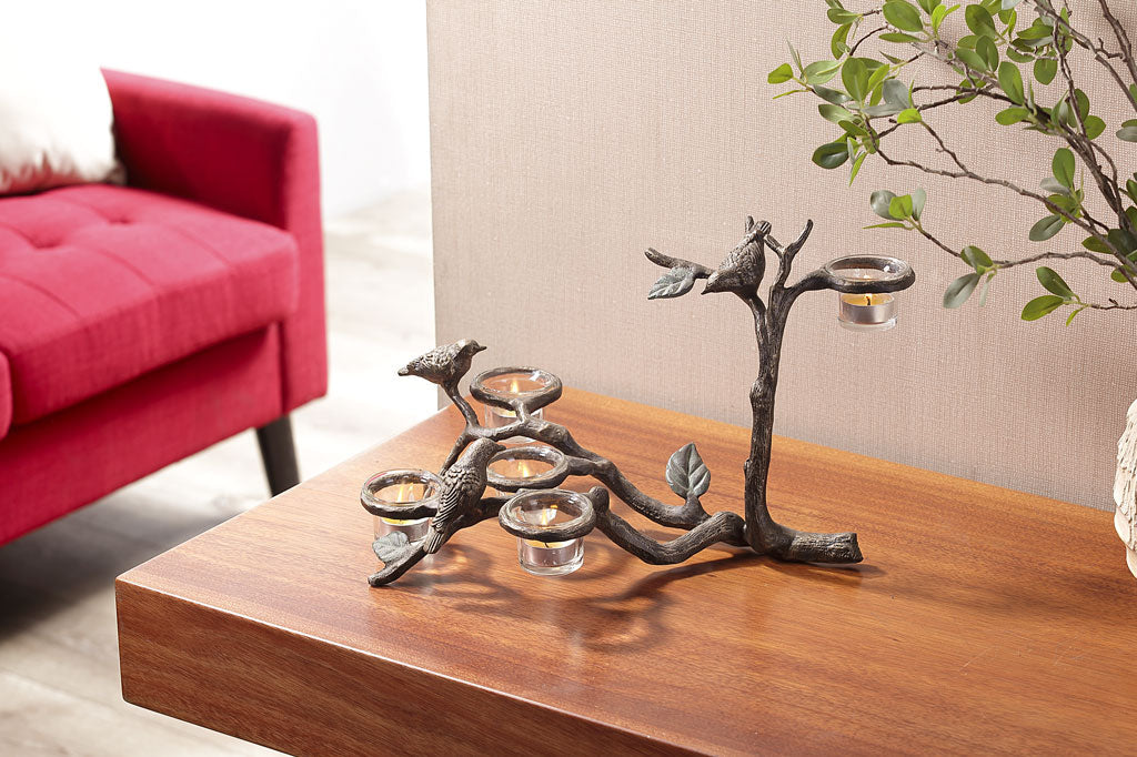 bird and branch table candelabra with 3 birds, holds 5 tealights in glass cups on table in living room with red couch