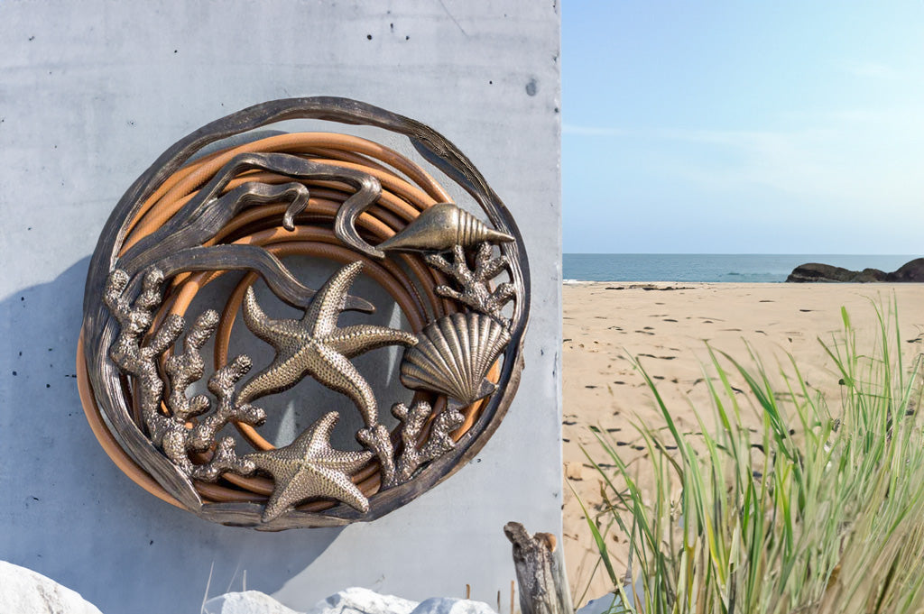 Under The Sea Hose Holder mounted on a wall by a grassy beach dune