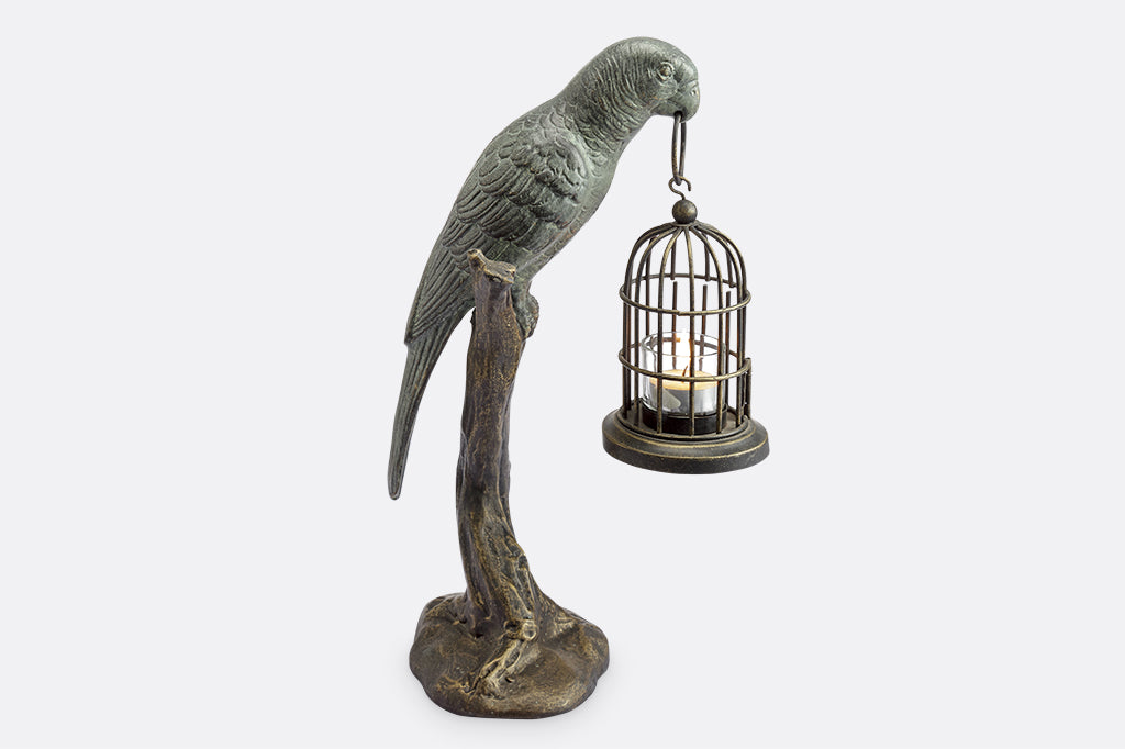 cast metal parrot seating on branch holding birdcage with tealight sculpture