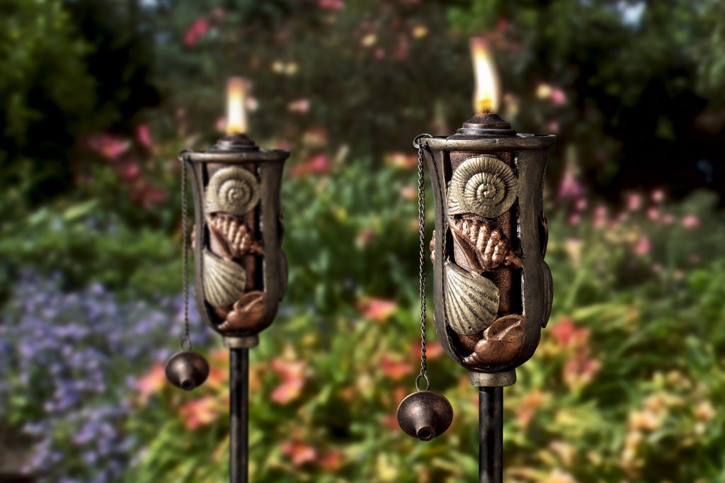 Cast metal oil torch with shell detailing