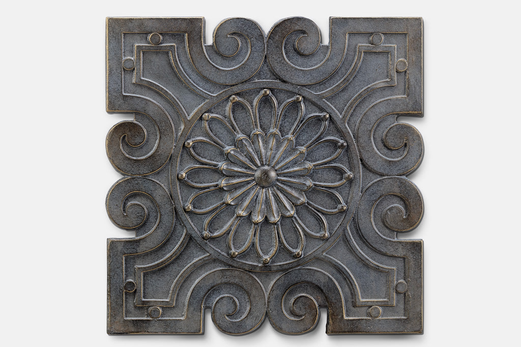 cast metal geometric wall tile with floral design in center