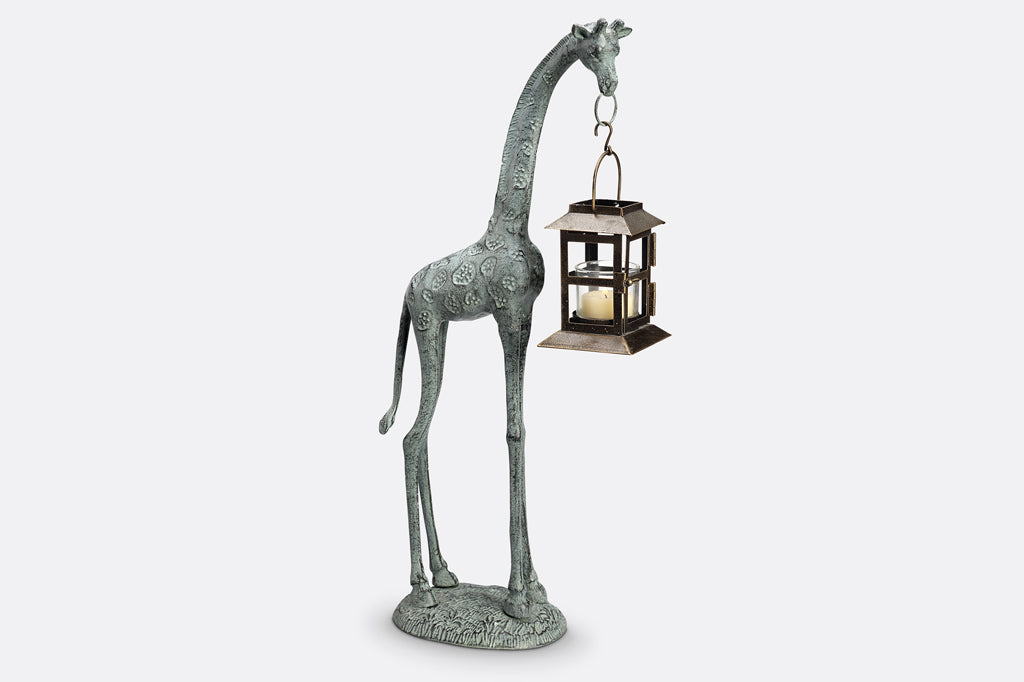 cast metal giraffe holding lantern in mouth sculpture