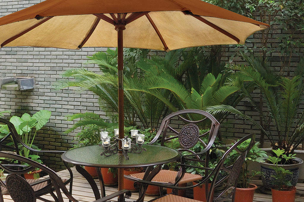 zoomed out images of candelabra around umbrella on outdoor table