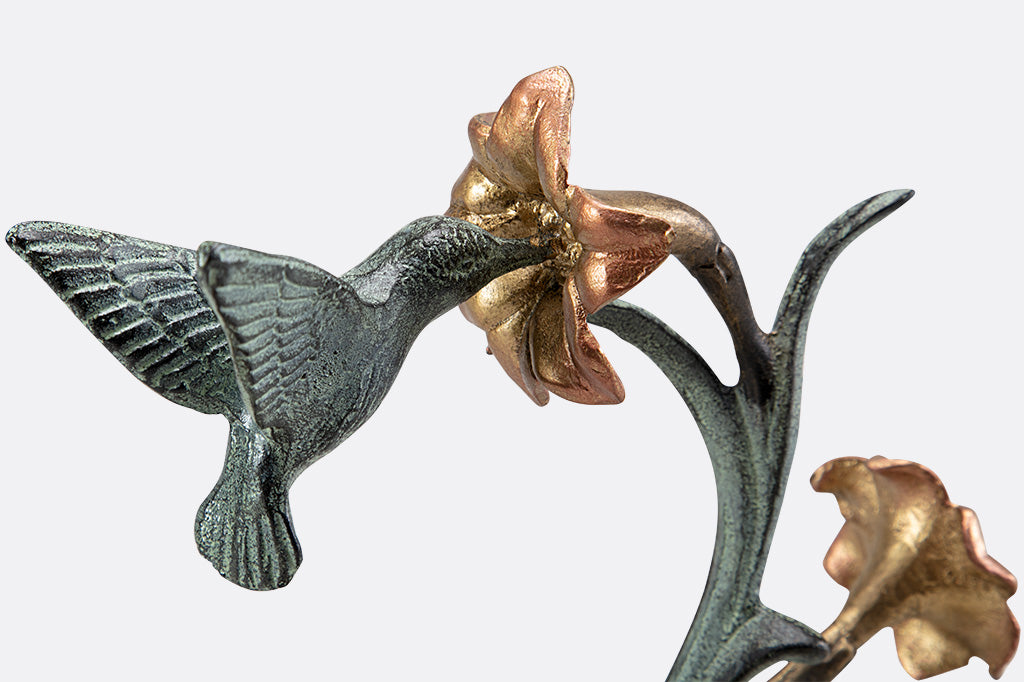 jewelry holder shaped like growing lily with humming bird visiting it.
