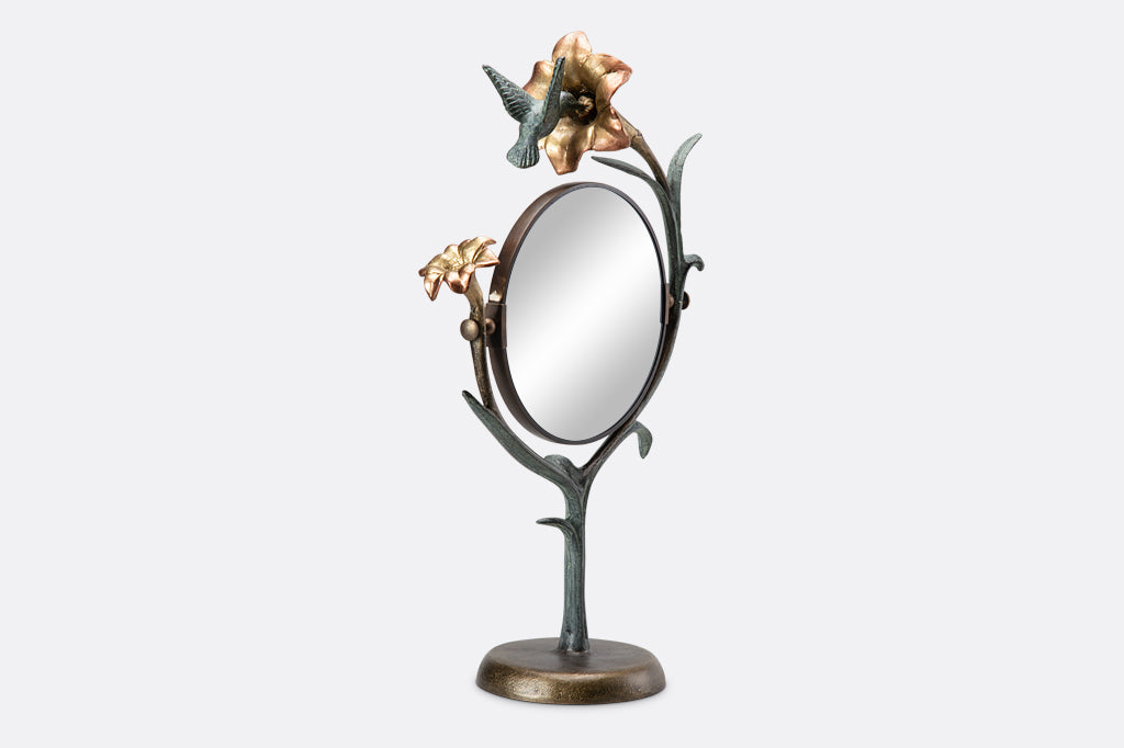 vanity mirror shaped like growing lily with humming bird visiting it.