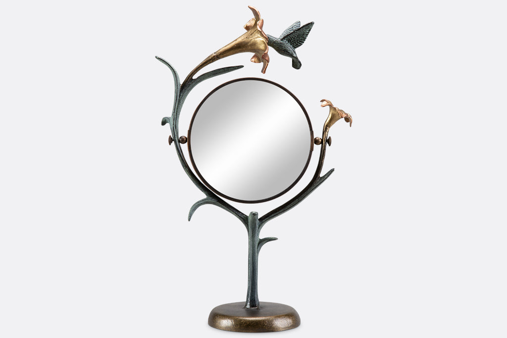 vanity mirror shaped like growing lily with humming bird visiting it.