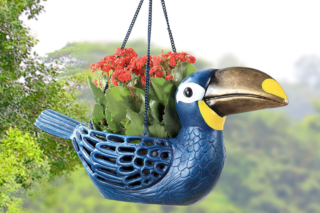 Cast metal toucan hanging planter, blue toucan with gold and yellow beak. Holding red and green succulent plant