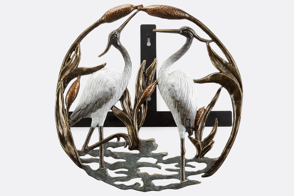 hose holder with motif of two white herons standing in cattail reeds