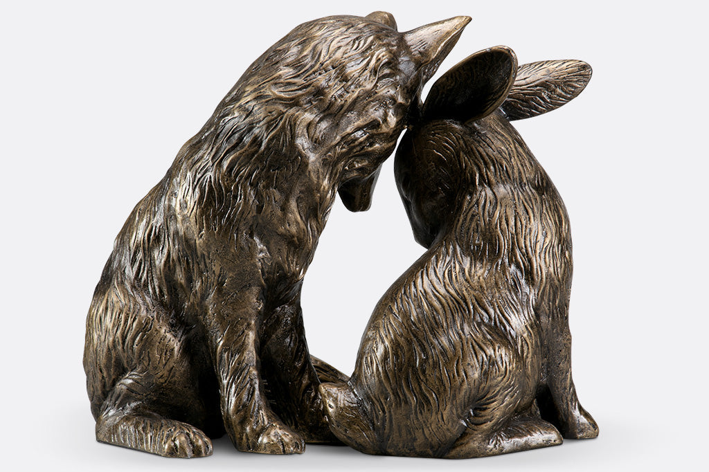 back view of garden sculpture of fox and rabbit tenderly nuzzling