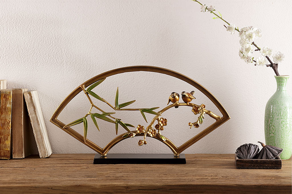 "tranquility sculpture" is a fan shaped table sculpture with bamboo, blossom, and bird features with shimmering features