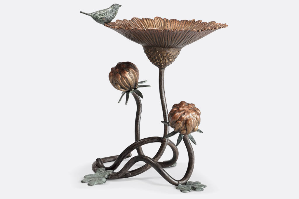 Clover and blossom shaped bird feeder has sculpted bird perched on rim