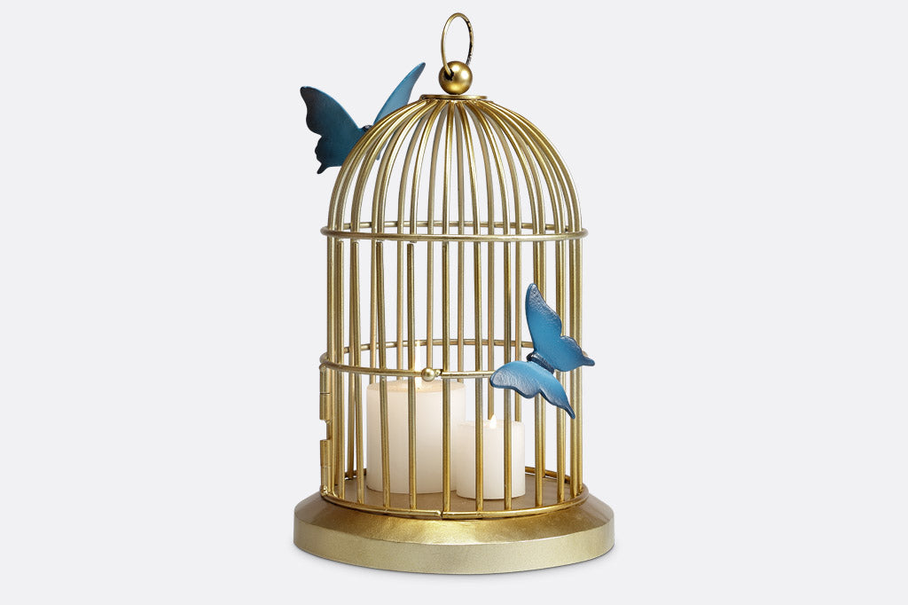 Butterflies of blue are sculpted onto a golden bird cage style plant or candle holder