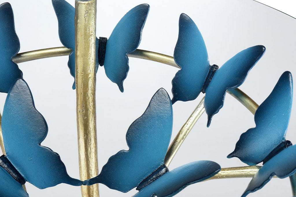 close up of sculpted blue butterfly under glass table top