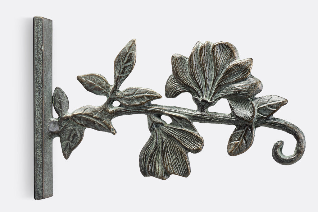 Two magnolia blossoms and a vine form a wall hook in the Magnolia Dawn Mounted Hanger