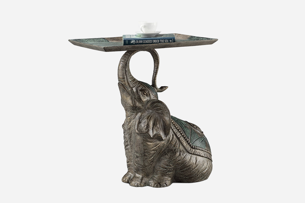 Indian elephant wearing palm motif blanket holds a tray embossed with palm branches
